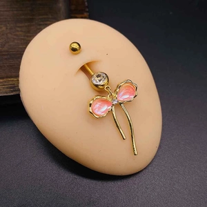 Gold-plated navel ring with pink bow pendant and shimmering tassels on model