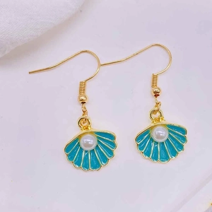 Detail of gold shell earrings with blue enamel, starfish motif and white pearl inlay