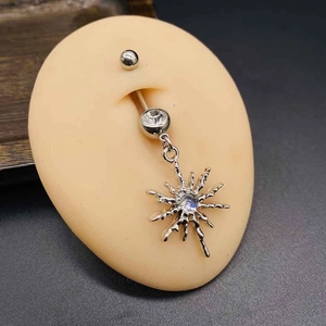 Detail of surgical steel belly ring featuring a sparkling star pendant and opal stone