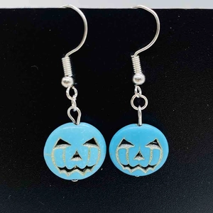 Détail macro de boucles d'oreilles citrouille bleue en turquoise pour Halloween avec crochets