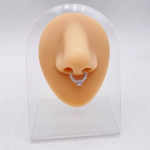 Gedetailleerde close-up van een zilveren septumring met zirkonia op een siliconen neus