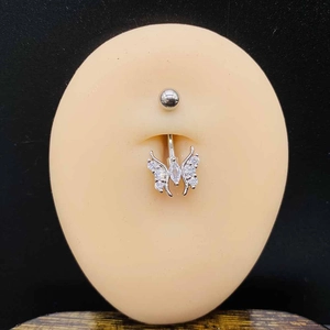 Vue macro d'un piercing nombril papillon avec zircons AAA sur modèle de corps