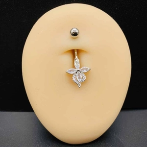 Vue détaillée d'un piercing de nombril en argent avec fleur en zircon sur modèle en silicone
