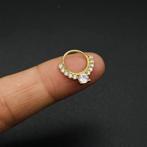Macro-opname van een vergulde neusring met zirkonia micro-pave op een zwarte achtergrond