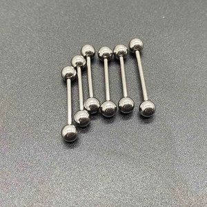 Λεπτομέρεια από πέντε ίσια σκουλαρίκια piercing από ανοξείδωτο ατσάλι σε σκοτεινή επιφάνεια