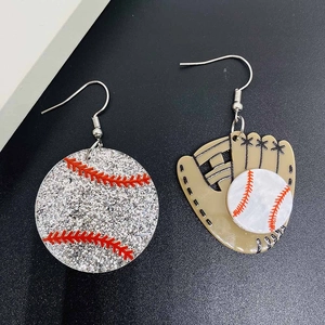 Boucles d'oreilles asymétriques baseball et gant en acrylique sur fond noir texturé