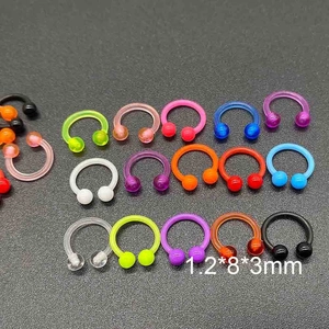 Détail macro de piercings circulaires 1,2x8x3mm en acrylique coloré pour parure