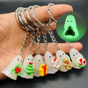 Set of six glowing resin ghost keychains featuring Christmas elements on a grey background