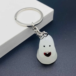 Detail of cute white ghost keychain with red heart and silver metal ring chain
