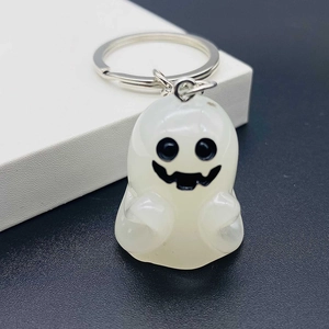 Close-up of a white resin ghost keychain with a cute black smiley face for Halloween