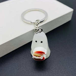 Close-up of cute white resin ghost keychain with a tiny coffee cup and silver ring