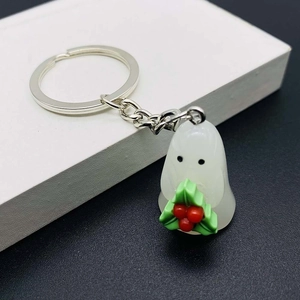 Luminous resin ghost keychain detail with Christmas holly decoration and silver chain link