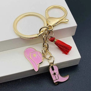 Pink western cowboy hat and boot keychain with red tassel and gold enamel stars