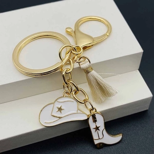 Western cowboy keychain featuring pink enamel hat, boots and tassel charm in gold finish