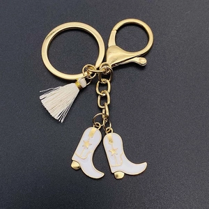 Western style golden keychain with white fringe tassel and starry cowboy boot charms