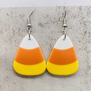 Halloween Candy Corn Acryl Ohrringe mit orange-gelben Streifen auf Stein Hintergrund