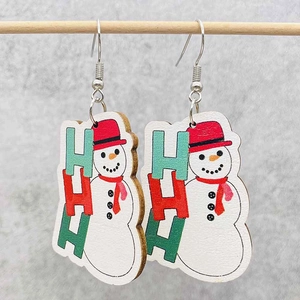 Dettaglio di orecchini natalizi in legno con motivo a pupazzo di neve e testo HO