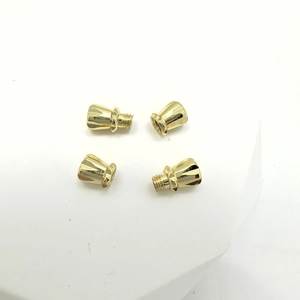 Macro shot of gold-plated bow screw clasps showing precise vertical facets and threads