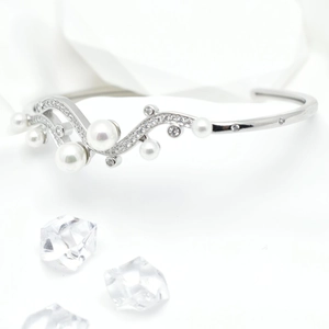 Elegant 18k gold wave bangle featuring shimmering zircons and round white pearls