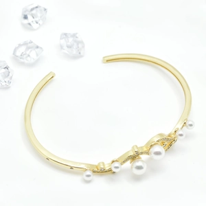 Elegant 18k gold plated wave bangle with white pearls and sparkling cubic zirconia stones