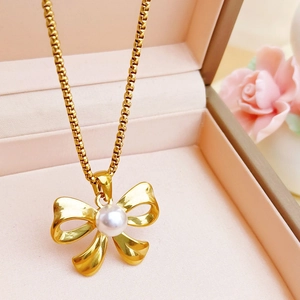 Elegant gold-plated pearl bow necklace set in a luxury pink jewelry box with roses