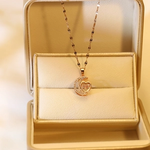 Detail of rose gold moon and heart pendant with dancing stone and pavé setting