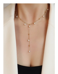 Détail du collier en Y de style français avec perles blanches et chaîne en or 18k