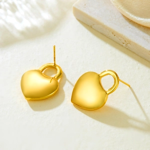 Minimalist gold heart-shaped lock earrings on stone background for women