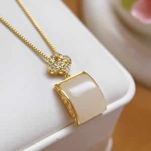 Elegant gold necklace with white rectangular jade pendant and sparkling flower zirconia detail
