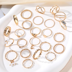 Set di 24 anelli dorati alla moda con perle e motivi a stella su vassoio in ceramica