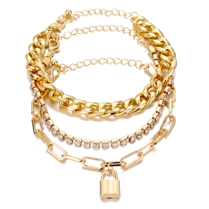 Set de cuatro cadenas de eslabones dorados, tenis y clip con colgante de candado