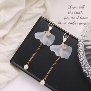 Detail of ballet dancer silhouette gold earrings with long tassels and pearls