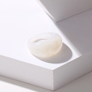 Close-up of white translucent resin chunky ring with marble texture on stone