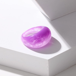 Macro shot of wide resin ring with purple marble texture on white geometric stone