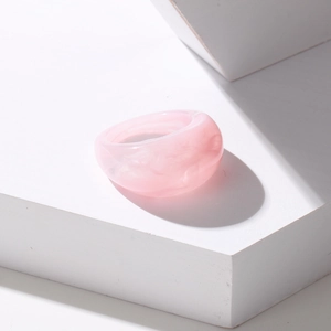 Pink resin ring with marble texture on white geometric block minimalist aesthetic