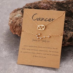 Details des Krebs-Sternzeichen-Halsketten- und Diamantarmband-Sets auf Kraftpapierkarte