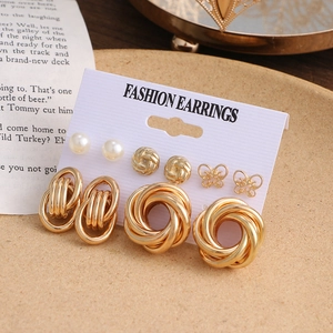 Detailansicht goldener Ohrring-Set mit Perlen und geometrischen Designs auf Displaykarte