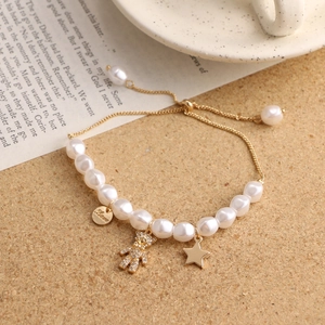 Detailed shot of pearl bracelet with bear charm and Love tag on aesthetic background
