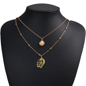 Collier multicouche doré rétro avec perles et pendentifs coquillages irisés sur un buste