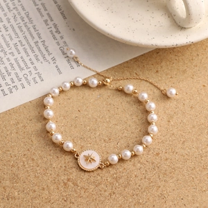 Detailed macro of a vintage pearl bracelet with gold star charm on a rustic background