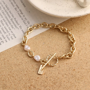 Detail of vintage gold chain bracelet with double heart pearls and T-bar closure
