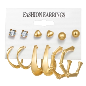 Set of 6 golden earrings featuring heart studs and bamboo style hoops on white display