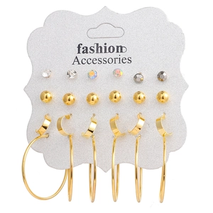 Lot de 9 paires de boucles d'oreilles dorées avec strass et créoles sur carte grise