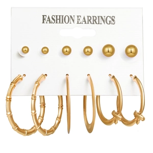 Detailed set of 6 pairs golden ball studs and hoop earrings on white display card