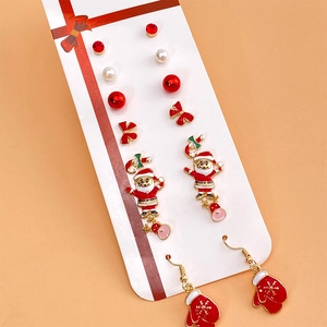 Christmas earring set featuring Santa, snowflakes, and pearls on a festive display card