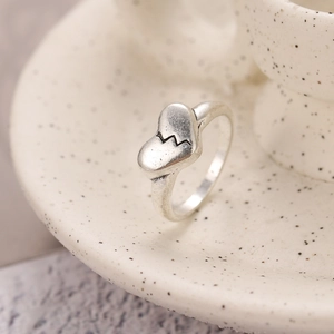 Detailopname van vintage zilveren ring met gebroken hart ontwerp op keramiek