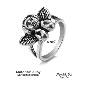 Detailed close-up of retro silver angel ring showing wing textures and alloy material