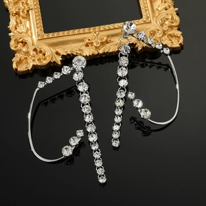 Macro view of sparkling crystal butterfly ear cuffs with elegant silver tassel drops