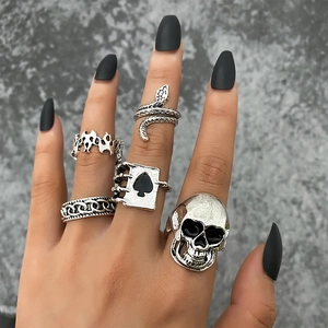 Détail d'un lot de 5 bagues rétro en argent avec motifs tête de mort, serpent et as de pique