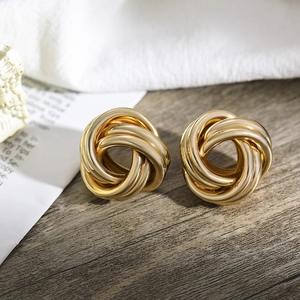 Detailansicht goldener verknoteter Ohrstecker mit strukturierter Vintage-Metalloberfläche